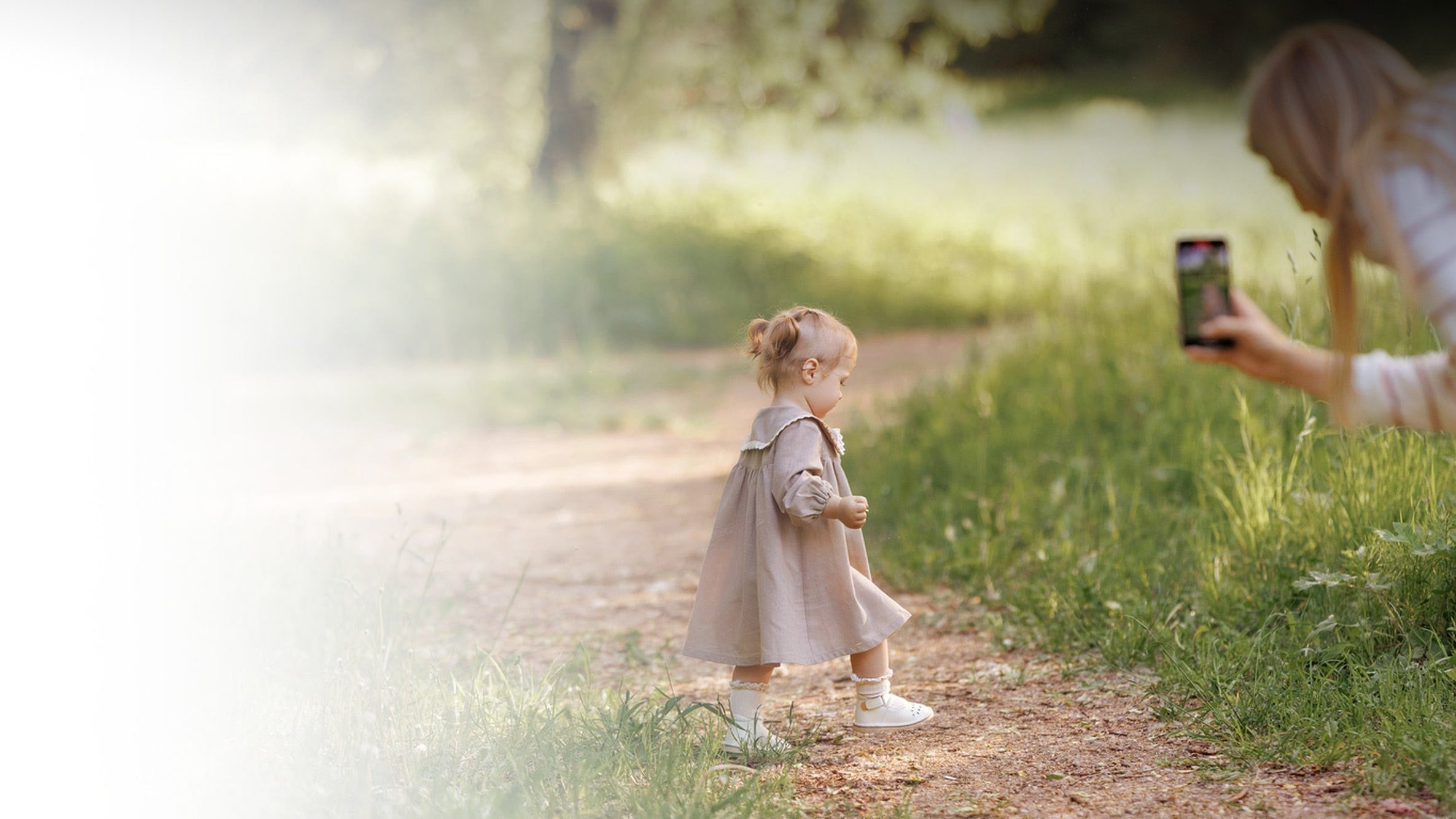 Mother taking phone videos of her young daughter that she will later get edited by a professional video editing service.
